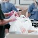 people in t-shirts fill carrier bags with meals for people in need
