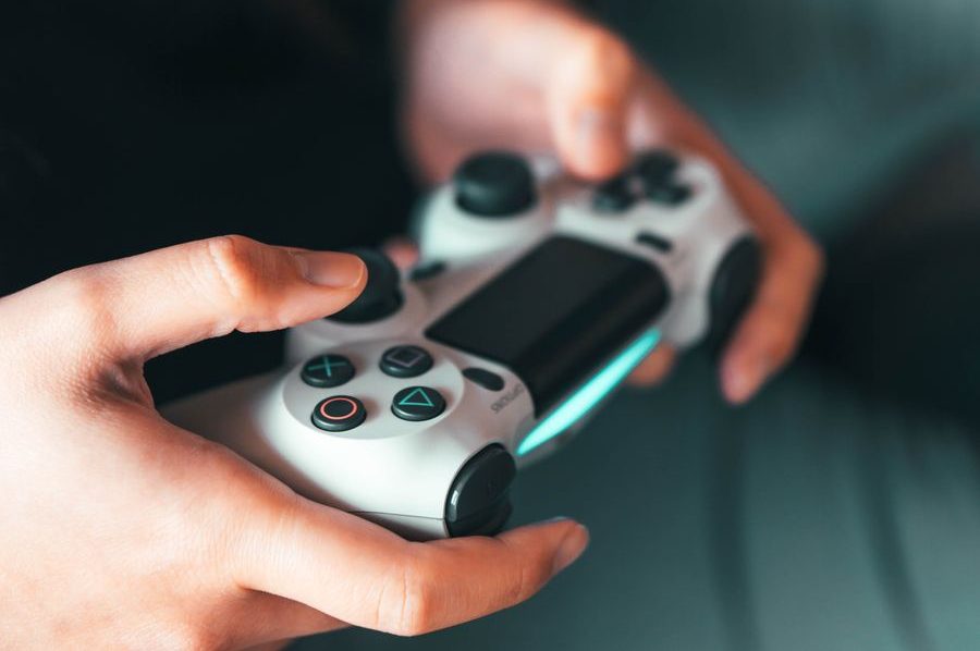 hands holding a grey games console