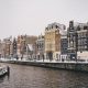 A snowy Amsterdam showing the buildings along the water