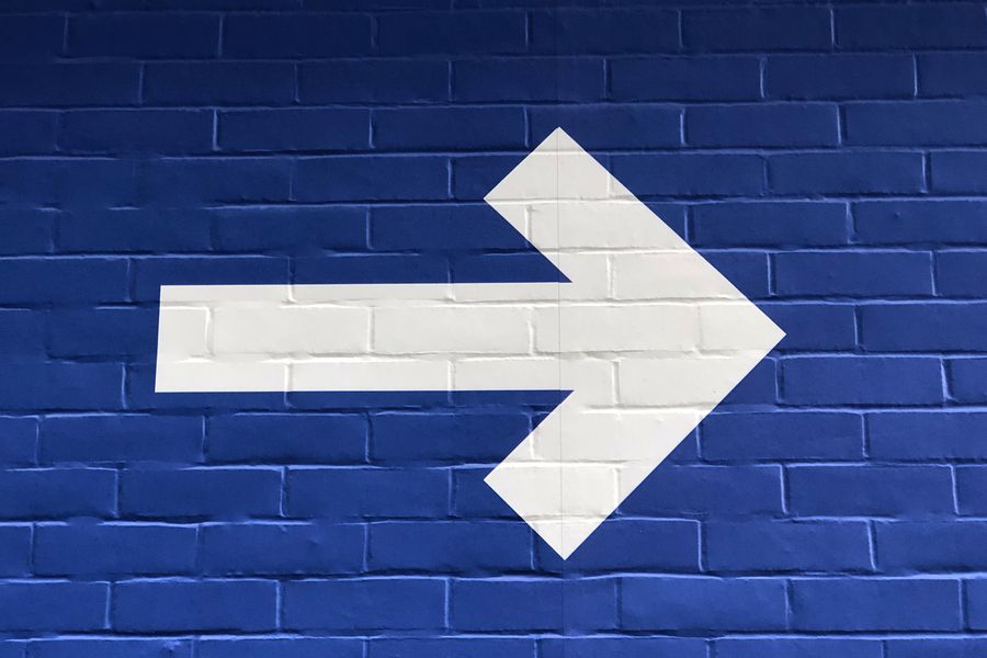 a white arrow points right on a dark blue background