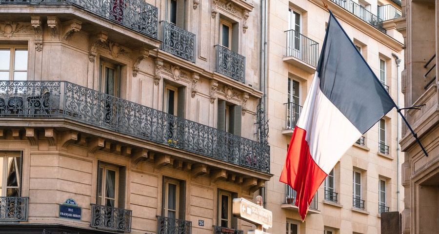 A French flag hangs outside a building