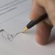 A close up of a hand signing a document. By Pixabay on Pexels
