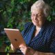 An older woman smiles as she looks at her Apple ipad. By Anna Shvets on Pexels
