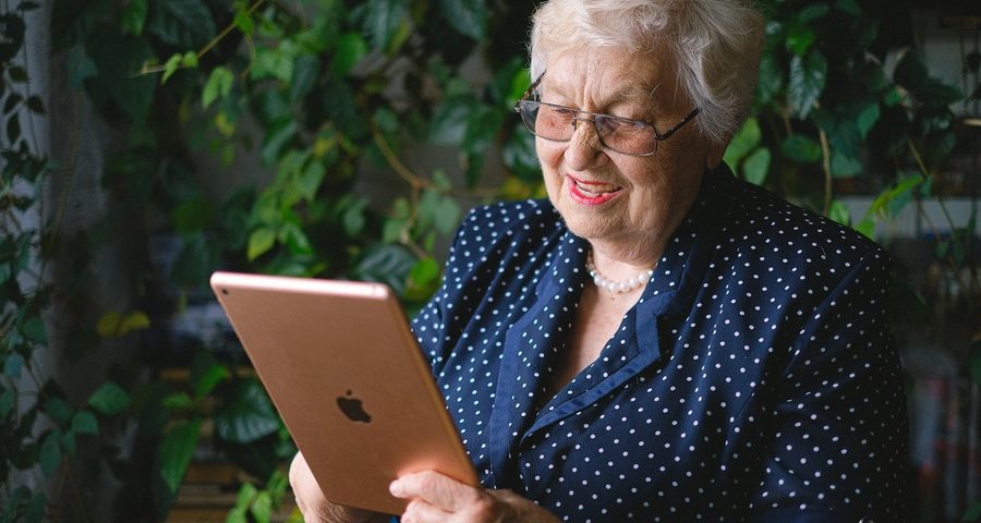 An older woman smiles as she looks at her Apple ipad. By Anna Shvets on Pexels