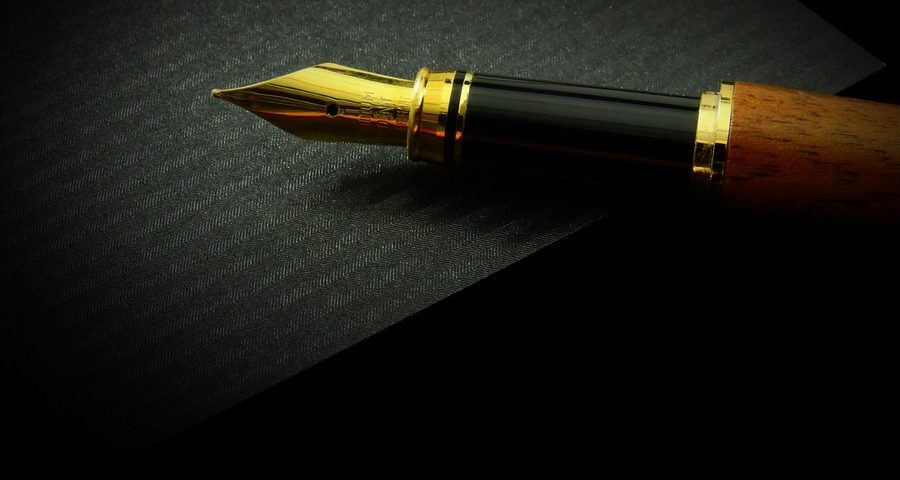 A fountain pen against a black background