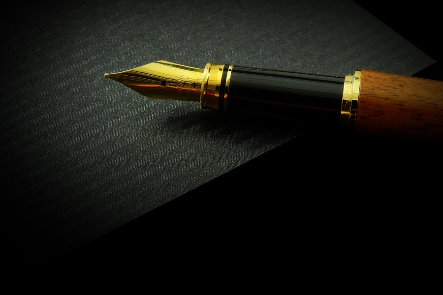 A fountain pen against a black background