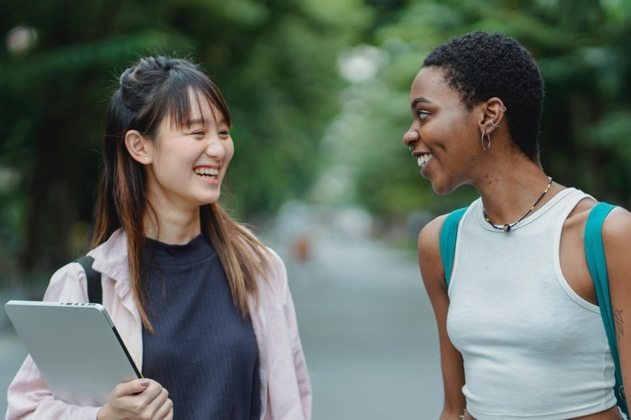 two women chat in the street. By Zen Chung on Pexels