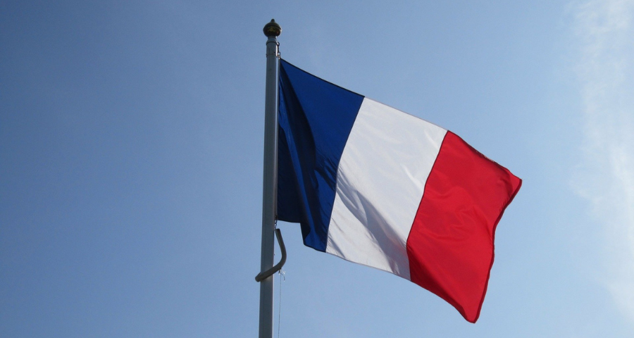 The French flag against a blue sky. By publicdomainpictures on Pixabay
