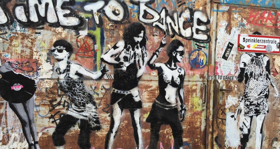 Graffiti on a wall showing dancing people. By ingeborgkraka on Pixabay