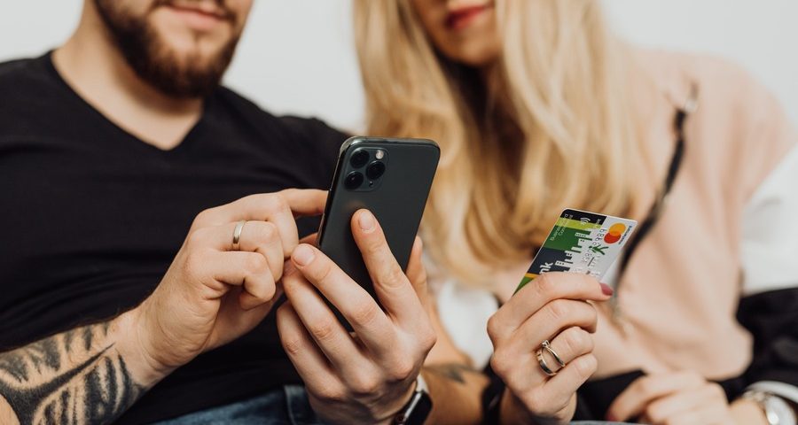 A man and woman with a phone and debit card. By Karolina Grabowska on Pexels
