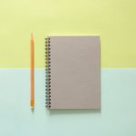 A notebook and pencil. By Tirachard Kumanom on Pexels