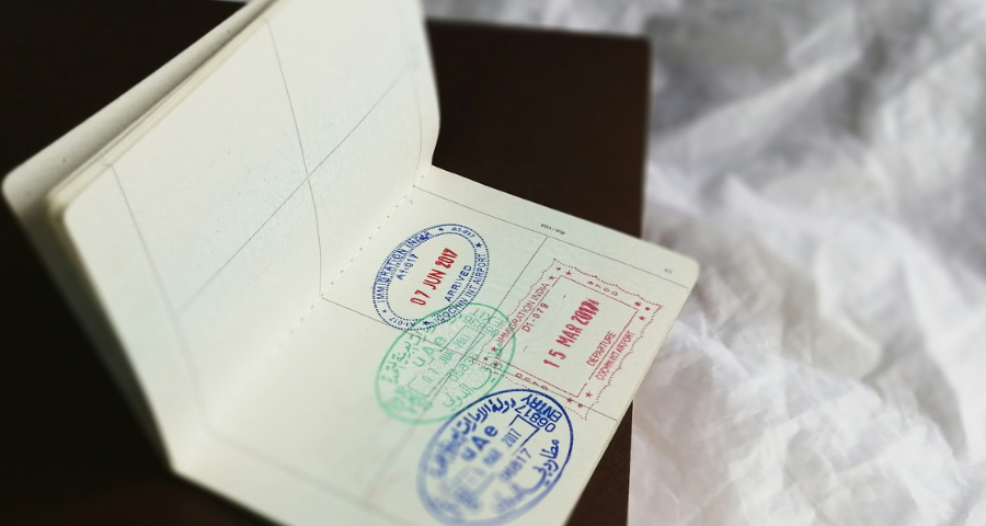 An open passport showing different country stamps. By Global Residence Index via Unsplash.