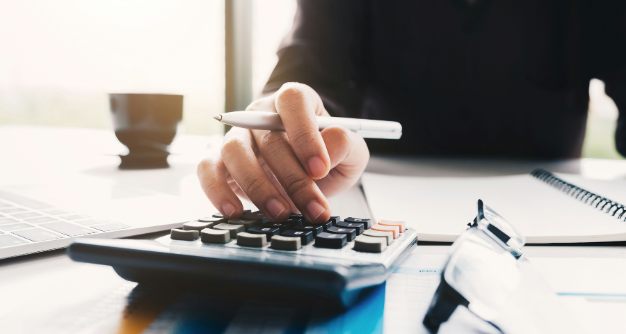 A hand doing a sum on a calculator. By Getty Images on Unsplash+