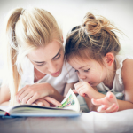 A mother reading with her young daughter. By Getty Images for Unsplash+