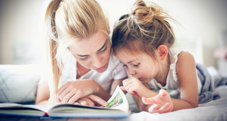 A mother reading with her young daughter. By Getty Images for Unsplash+