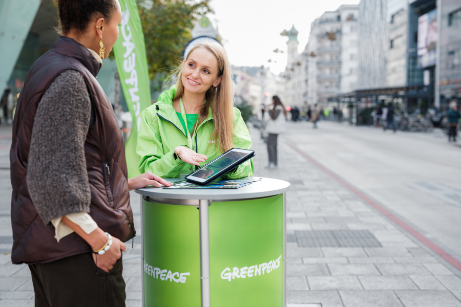A Greenpeace F2F fundraiser talks to a woman on the street.