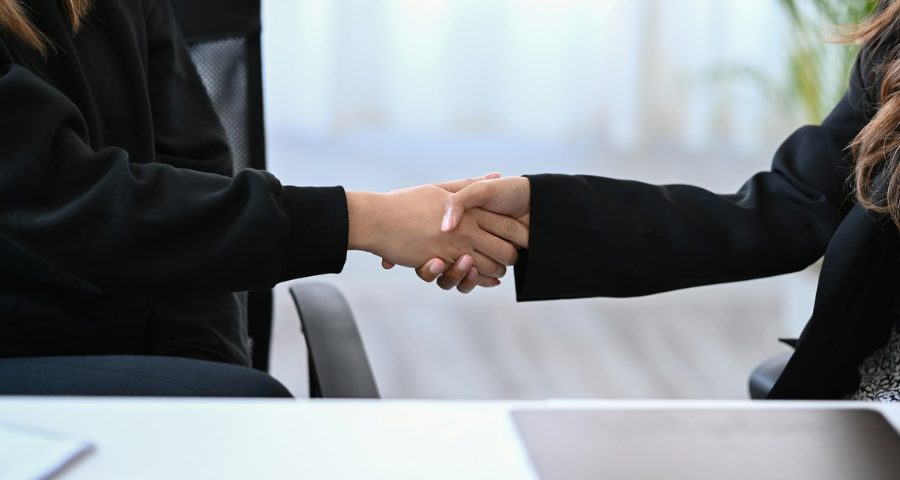 Two business women shaking hands. By Getty Images for Unsplash+