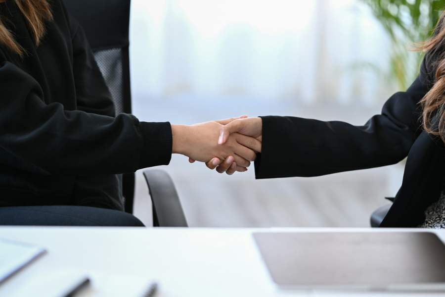 Two business women shaking hands. By Getty Images for Unsplash+