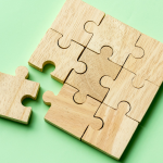A wooden puzzle with a displaced piece by Curated Lifestyle on Unsplash+