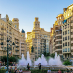 A group of people standing around a big fountain in Valencia Spain
