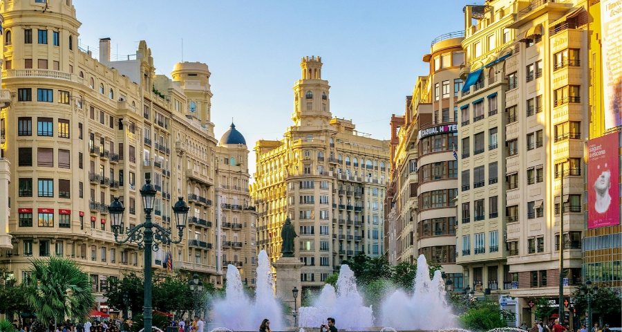 A group of people standing around a big fountain in Valencia Spain